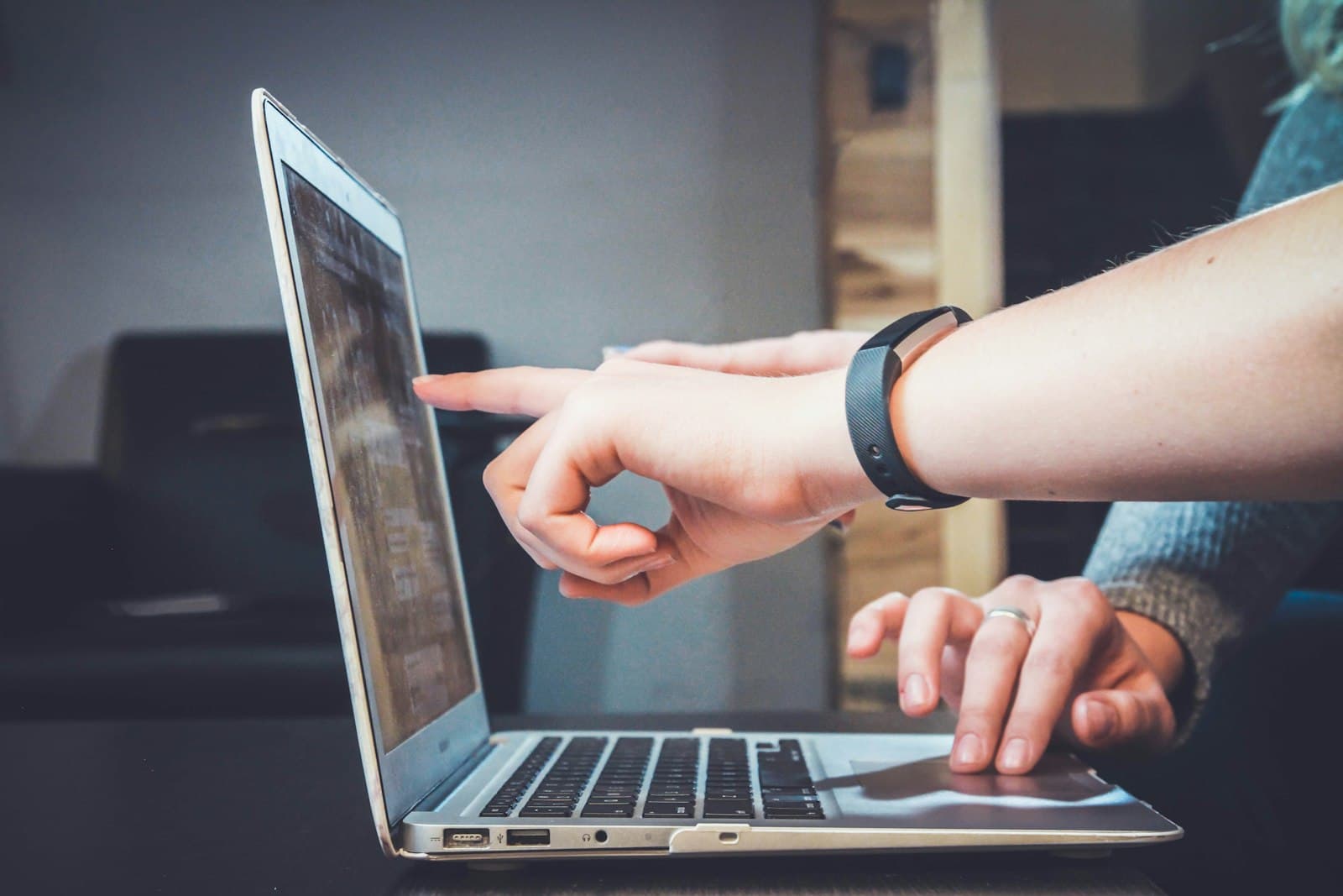 Hand pointing at a laptop screen during an onboarding walkthrough